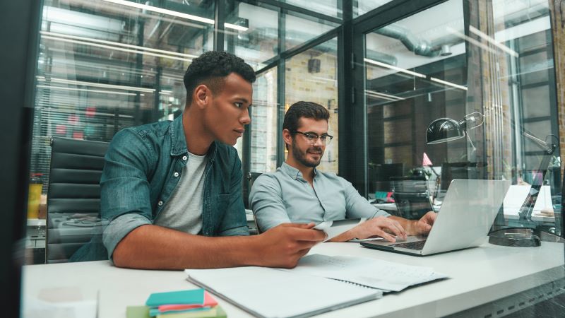 Calculadora de gargalo: dois homens trabalhando em escritório.