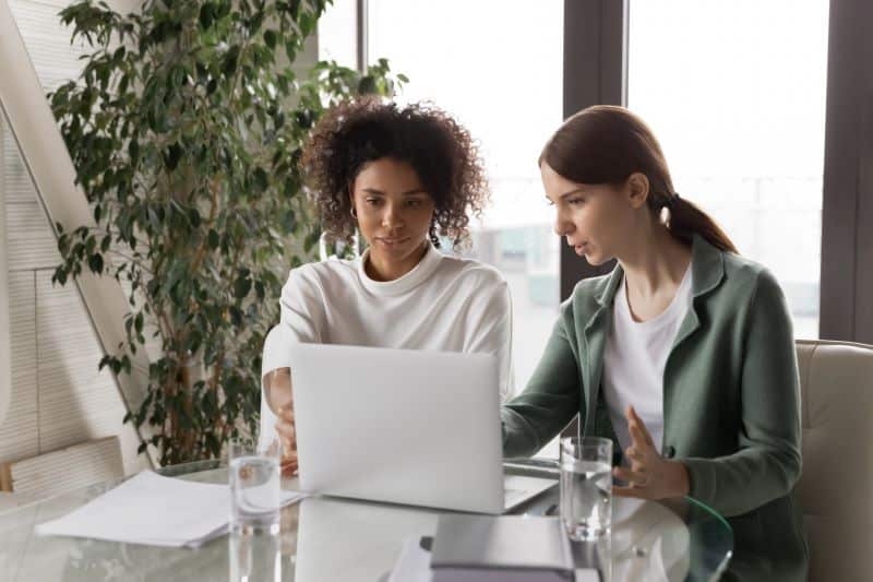 calculadora de juros e multa: duas mulheres trabalhando em notebook em escritório
