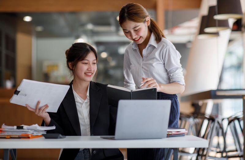 plano de contas contábeis: mulheres trabalhando no computador e com documentos no escritório