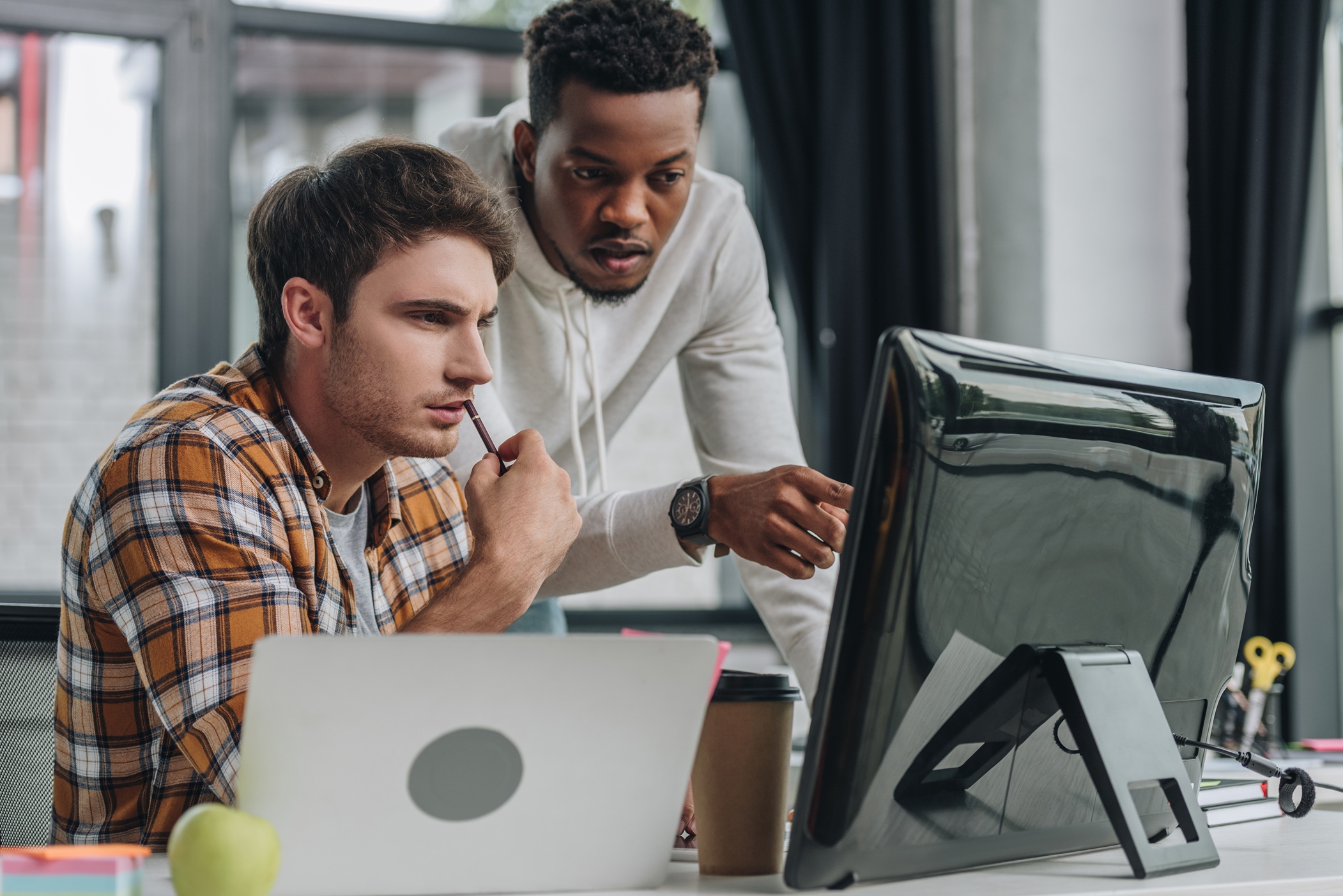 Dois homens trabalhando e apontando para o computador